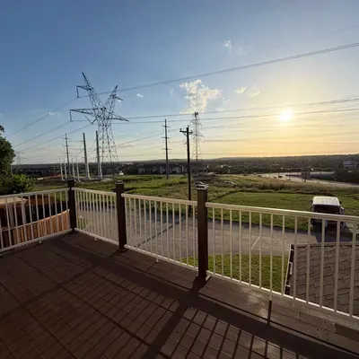 Composite deck build with metal cable railing at sunset — Celina, TX | Goldstar Renovations